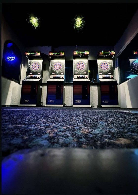 Dartautomaten in einer dunklen Spielhalle.